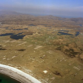 General oblique aerial view centred on the crofting township and the machair with Stulabhal in the distance, taken from the SW.