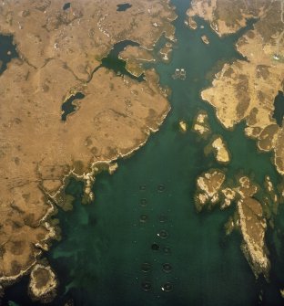 Oblique aerial view centred on the fish farm (NF 8757 4883) with the house adjacent, taken from the SE.