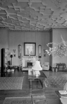 Interior view of Guthrie Castle showing room with fireplace and with Scottish National Buildings Record photographer Colin McWilliam reflected in a mirror.