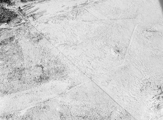 Oblique aerial view centred on the remains of a hut circle at Butterwards, looking to the NNE.