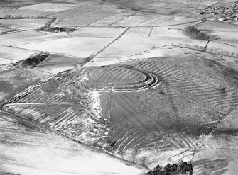 Oblique aerial view centred on the remains of the fort and rig and furrow at Barra Hill, looking to the NNW.