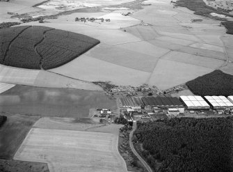 Oblique aerial view centred on the excavation of the earthwork and enclosure at Thomshill with Glenlossie distillery adjacent, looking to the NNW.