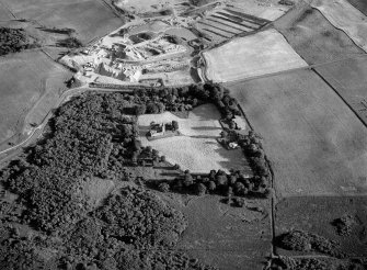 Oblique aerial view centred on the remains of Restenneth Priory  with pits and a possible souterrain adjacent, looking to the N.