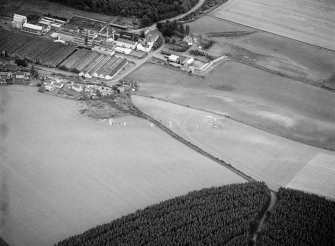Oblique aerial view centred on the excavation of the earthwork and enclosure at Thomshill with Glenlossie distillery adjacent, looking to the ESE.