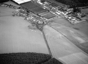 Oblique aerial view centred on the excavation of the earthwork and enclosure at Thomshill with Glenlossie distillery adjacent, looking to the E.