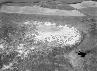 Oblique aerial view centred on the remains of hut circles, ring cairn and the midden at Sands of Forvie, looking to the WNW.