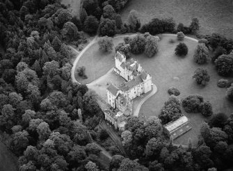 Oblique aerial view centred on Fyvie Castle with the racquets court adjacent, looking to the SSE.