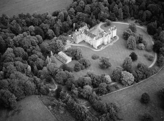 Oblique aerial view centred on Fyvie Castle with the racquets court adjacent, looking to the NE.