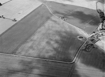 Oblique aerial view centred on the cropmarks of the pit alignment, pit enclosure, possible barrows and rig at Inchbare, looking to the SSW.