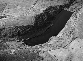 Oblique aerial view centred on the Den of Boddam reservoir, flint mines and lithic working site, looking to the NNW.