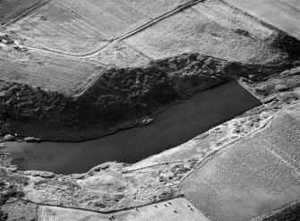 Oblique aerial view centred on the Den of Boddam reservoir, flint mines and lithic working site, looking to the NW.