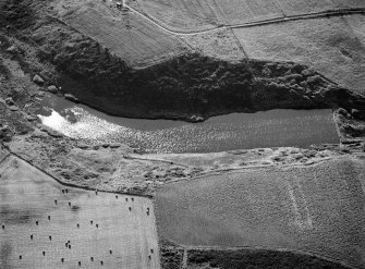 Oblique aerial view centred on the Den of Boddam reservoir, flint mines and lithic working site, looking to the WNW.