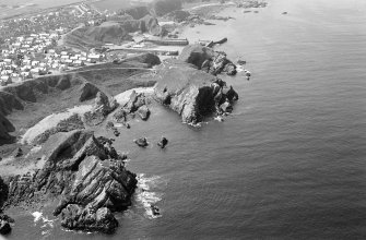 General oblique aerial view of Green Castle, Portnockie with the harbour beyond, looking to the SW.