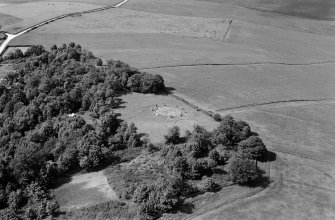 Oblique aerial view centred on the remains of the stone circle and enclosed cremation cemetery at Loanhead of Daviot, looking to the NW.