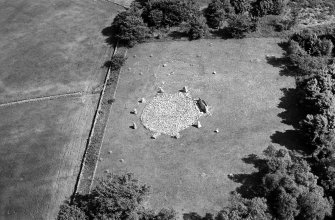Oblique aerial view centred on the remains of the stone circle and enclosed cremation cemetery at Loanhead of Daviot, looking to the ESE.