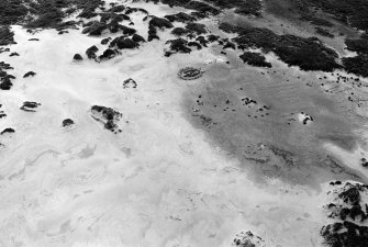 Oblique aerial view centred on the remains of hut circles and the midden at Sands of Forvie, looking to the NE.