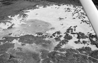 Oblique aerial view centred on the remains of hut circles and the midden at Sands of Forvie, looking to the SW.