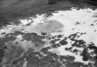 Oblique aerial view centred on the remains of hut circles and the midden at Sands of Forvie, looking to the SW.