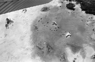 Oblique aerial view centred on the remains of hut circles and the midden at Sands of Forvie, looking to the NE.