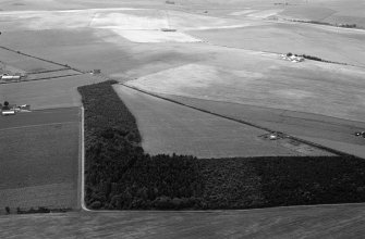 Oblique aerial view centred on the cropmarks of an enclosure at Garble Croft, looking to the S.