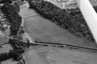 Oblique aerial view centred on the cropmarks of ring ditches, pits and possible souterrains at Nairn, looking to the SSE.