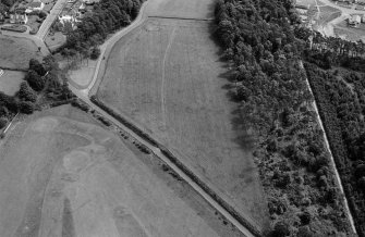 Oblique aerial view centred on the cropmarks of ring ditches, pits and possible souterrains at Nairn, looking to the ESE.