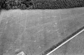 Oblique aerial view centred on the cropmarks of an enclosure at Garble Croft, looking to the E.