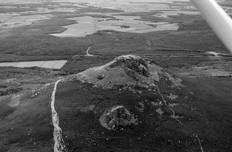 Oblique aerial view centred on the remains of the fort at Mither Tap of Bennachie, looking to the SSE.