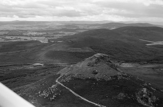 Oblique aerial view centred on the remains of the fort at Mither Tap of Bennachie, looking to the S.