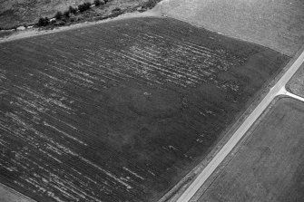 Oblique aerial view centred on the cropmarks of the circular enclosure at Barflat, looking to the SE.