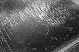 Oblique aerial view centred on the cropmarks of the circular enclosure at Barflat, looking to the SE.