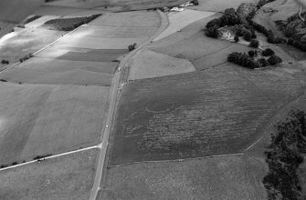 Oblique aerial view centred on the cropmarks of the circular enclosure at Barflat, looking to the NNE.