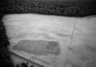 Oblique aerial view centred on the cropmarks of the ring ditch and possible henge at Berryley, looking to the ENE.