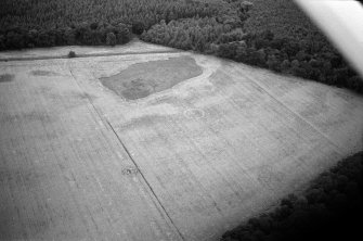 Oblique aerial view centred on the cropmarks of the ring ditch and possible henge at Berryley, looking to the ENE.