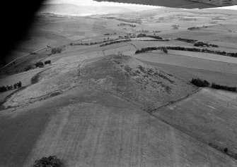 Oblique aerial view centred on the remains of the tower house and fort at Dunideer, looking to the E.
