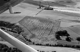 Oblique aerial view centred on the cropmarks of the circular enclosure at Barflat, looking to the WSW.