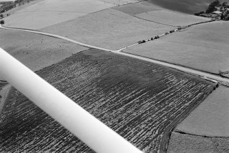 Oblique aerial view centred on the cropmarks of the circular enclosure at Barflat, looking to the SW.