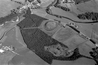 Oblique aerial view centred on the remains of the castle and motte of Doune of Invernochty, looking to the E.