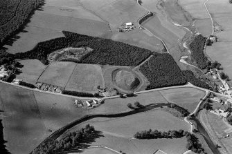 Oblique aerial view centred on the remains of the castle and motte of Doune of Invernochty, looking to the WNW.