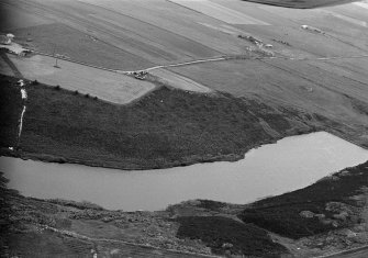 Oblique aerial view centred on the Den of Boddam reservoir, flint mines and lithic working site, looking to the WNW.