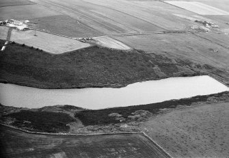 Oblique aerial view centred on the Den of Boddam reservoir, flint mines and lithic working site, looking to the WNW.