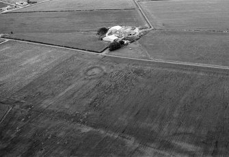 Oblique aerial view centred on the cropmarks of a circular enclosure at Shannas, looking to the SE.