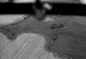 Oblique aerial view centred on the remains of the recumbent stone circle and dovecot, looking to the ESE.