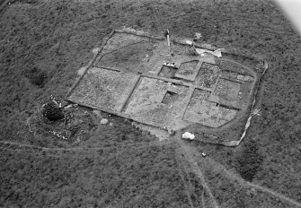 Oblique aerial view centred on the remains of the recumbent stone circle and dovecot, looking to the SE.