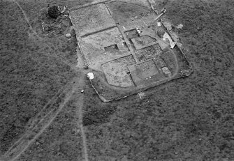 Oblique aerial view centred on the remains of the recumbent stone circle and dovecot, looking to the SSE.