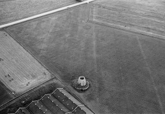 Oblique aerial view centred on the cropmarks of the ring ditch, pits and windmill at Sandend, looking to the SW.