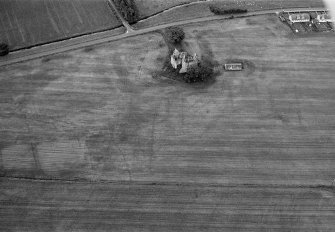 Oblique aerial view of Leslie Castle with cropmarks of linear features, pits and the moat ditch visible, looking to the SSW.
