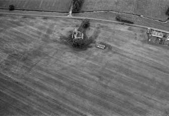 Oblique aerial view of Leslie Castle with cropmarks of linear features, pits and the moat ditch visible, looking to the SE.