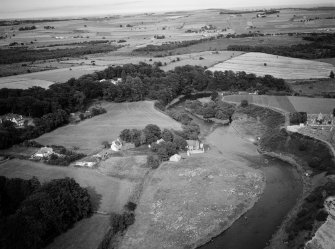Oblique aerial view centred on Cothal Mills, Dyce Old Parish Church and the River Don, looking to the NE.