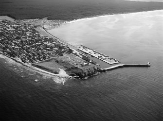 Oblique aerial view centred on the town and harbour of Burghead, looking to the SE.